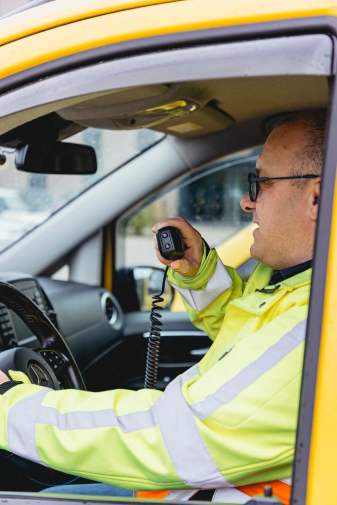Chauffeur gebruikt radio in gele auto